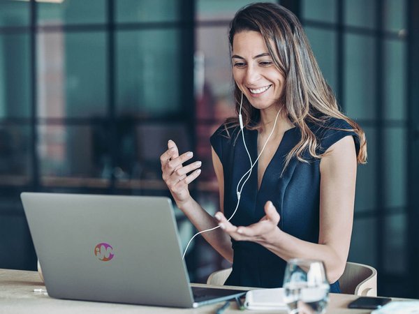 Eine Person, spricht zum Laptop, Kopfhörer