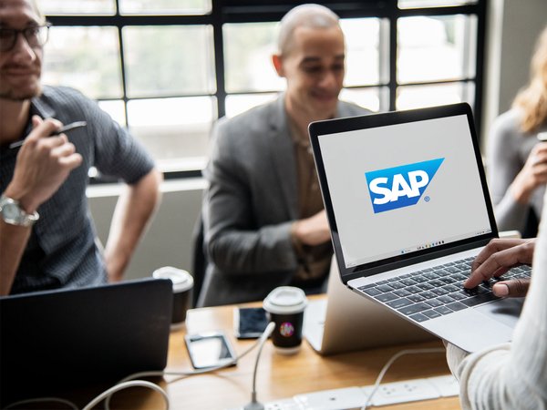 Laptop im Fokus an Gesprächstisch, SAP Logo
