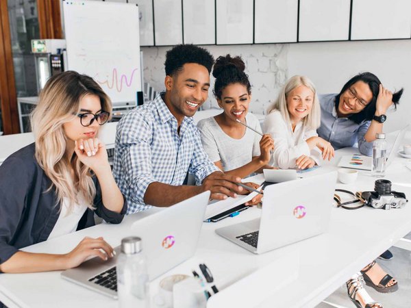 Gruppe Menschen im Büro schauen auf Laptop